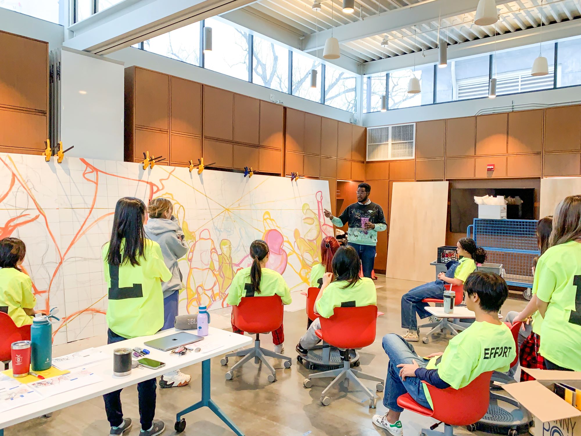 Stuart Robertson instructs students in the creative studio inside the Gruss Center for Art and Design where they created the mural