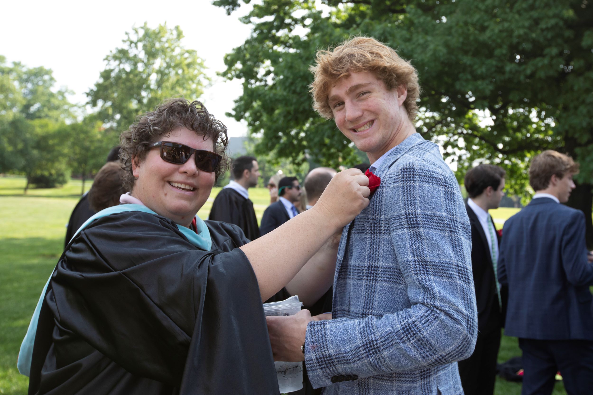 Teacher Kelly Wise helps a student putting on his boutonniere.