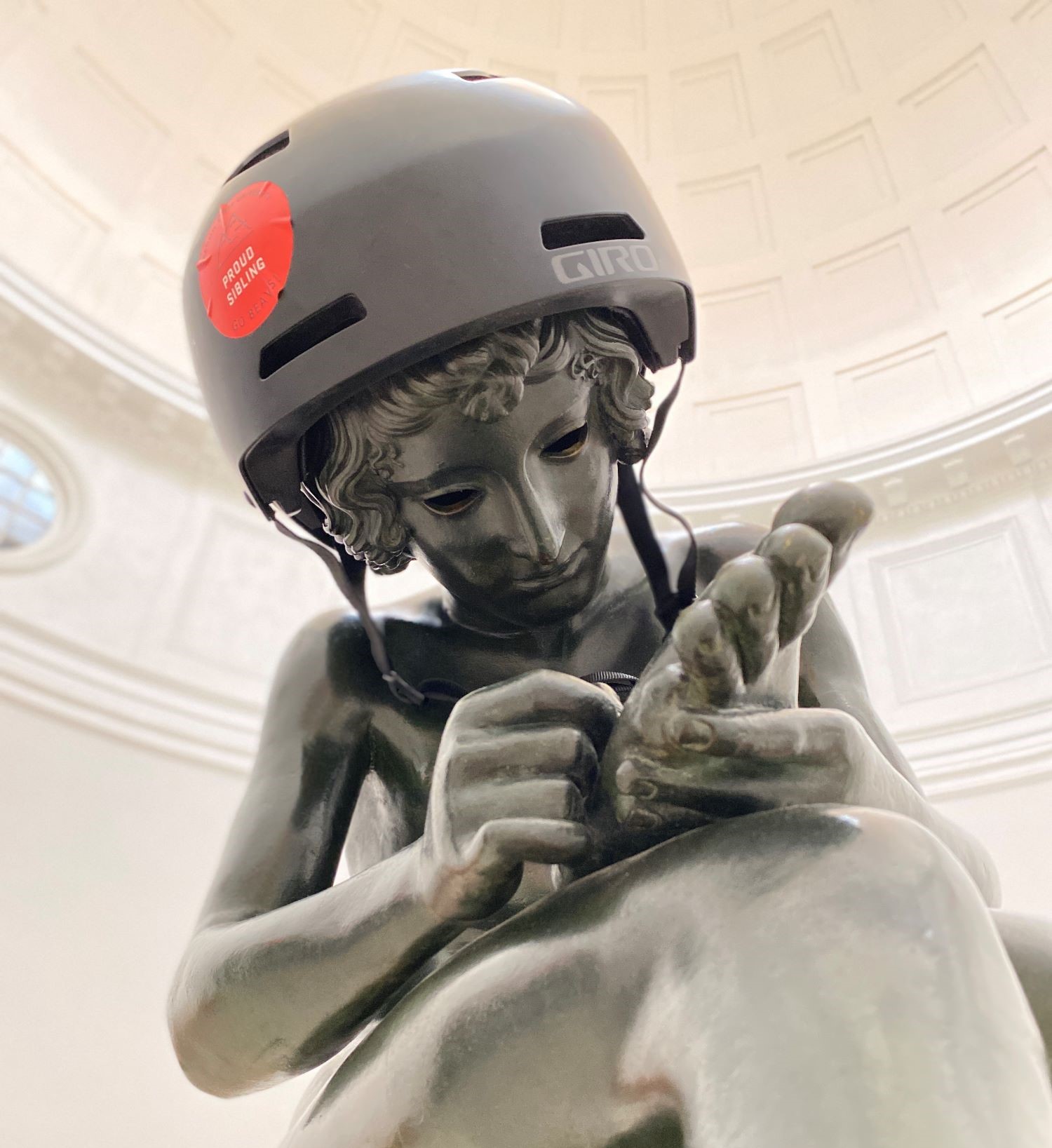 Spinario statue in the Pop Hall Rotunda wearing a skaters helmet.