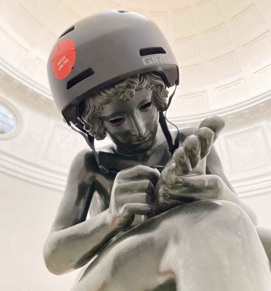 The Spinario statue in the Pop Hall rotunda, wearing a skaters helmet.