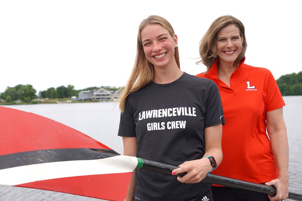 Vivian Teeley '24 and her mother, Bernadette Teeley, hold an oar at Mercer Lake.