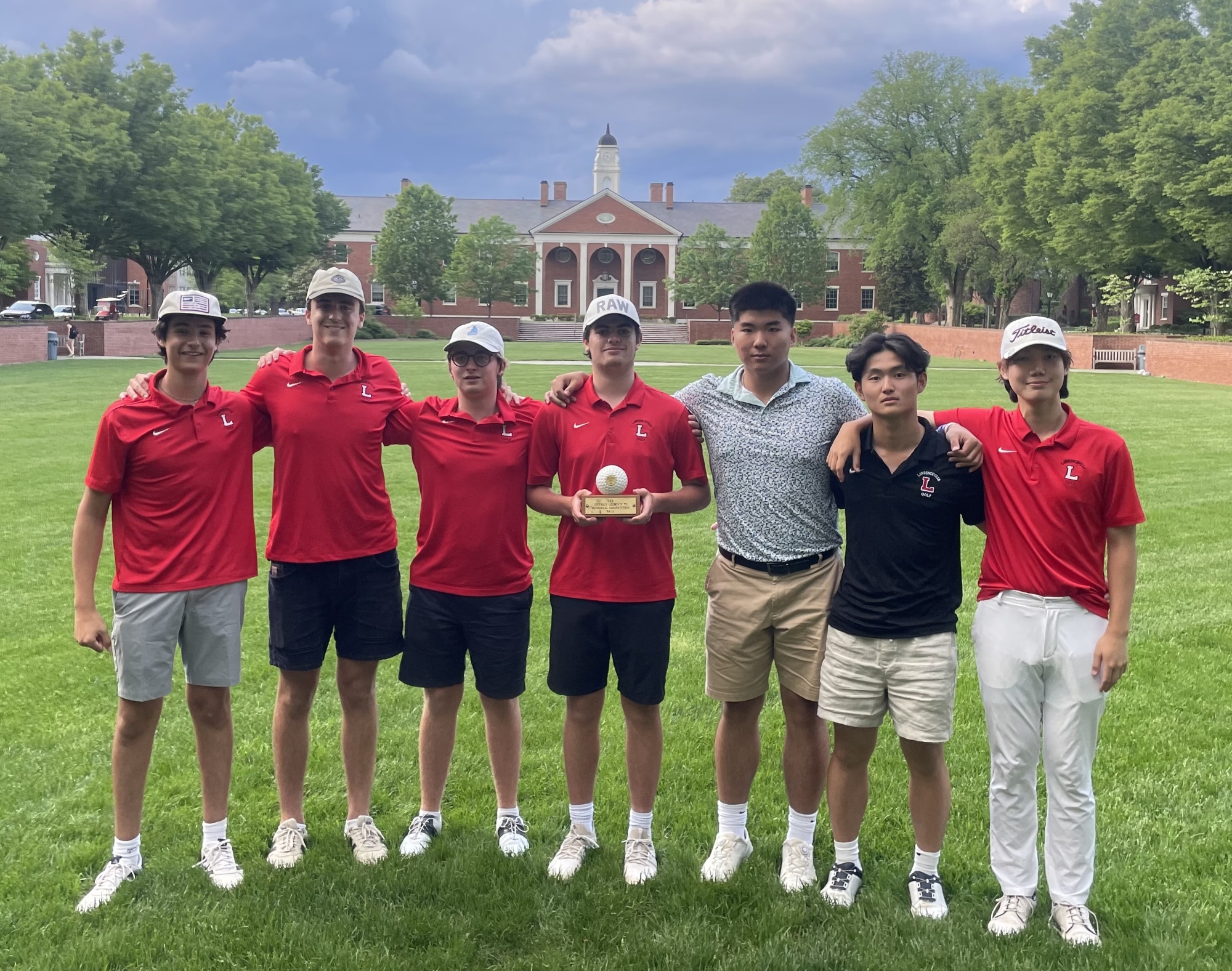 Members of the boys' golf team line up in the Bowl with their Leibovit Cup trophy