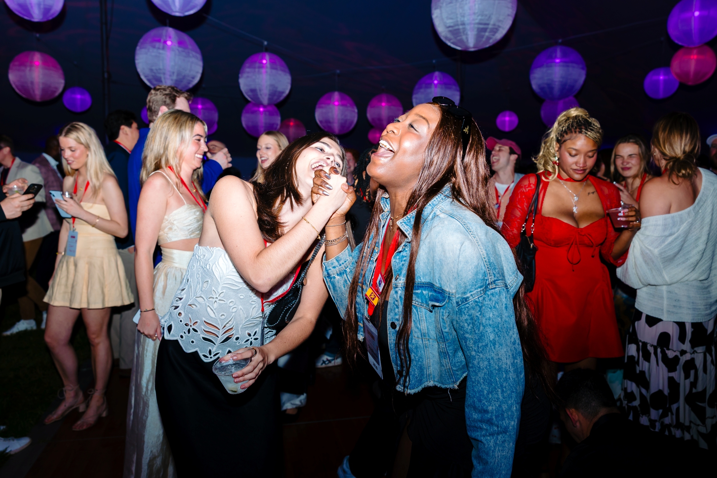 Two alumnae share an affectionate clasp of hands and laughter on the dance floor at Alumni Reunion Weekend 2025.
