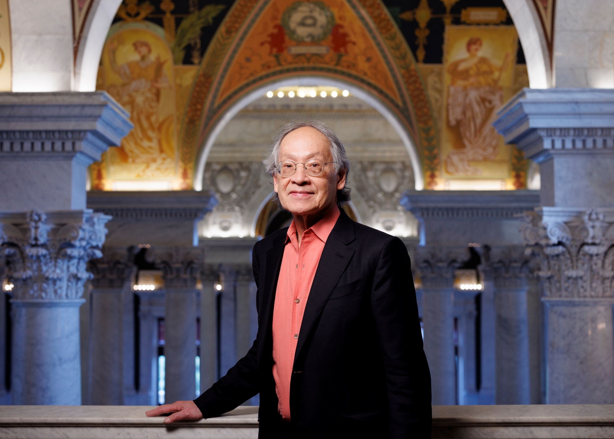 U.S. poet Laureate Arhtur Sze '68 stands with is hand on a marble railing at the Library of Congress.