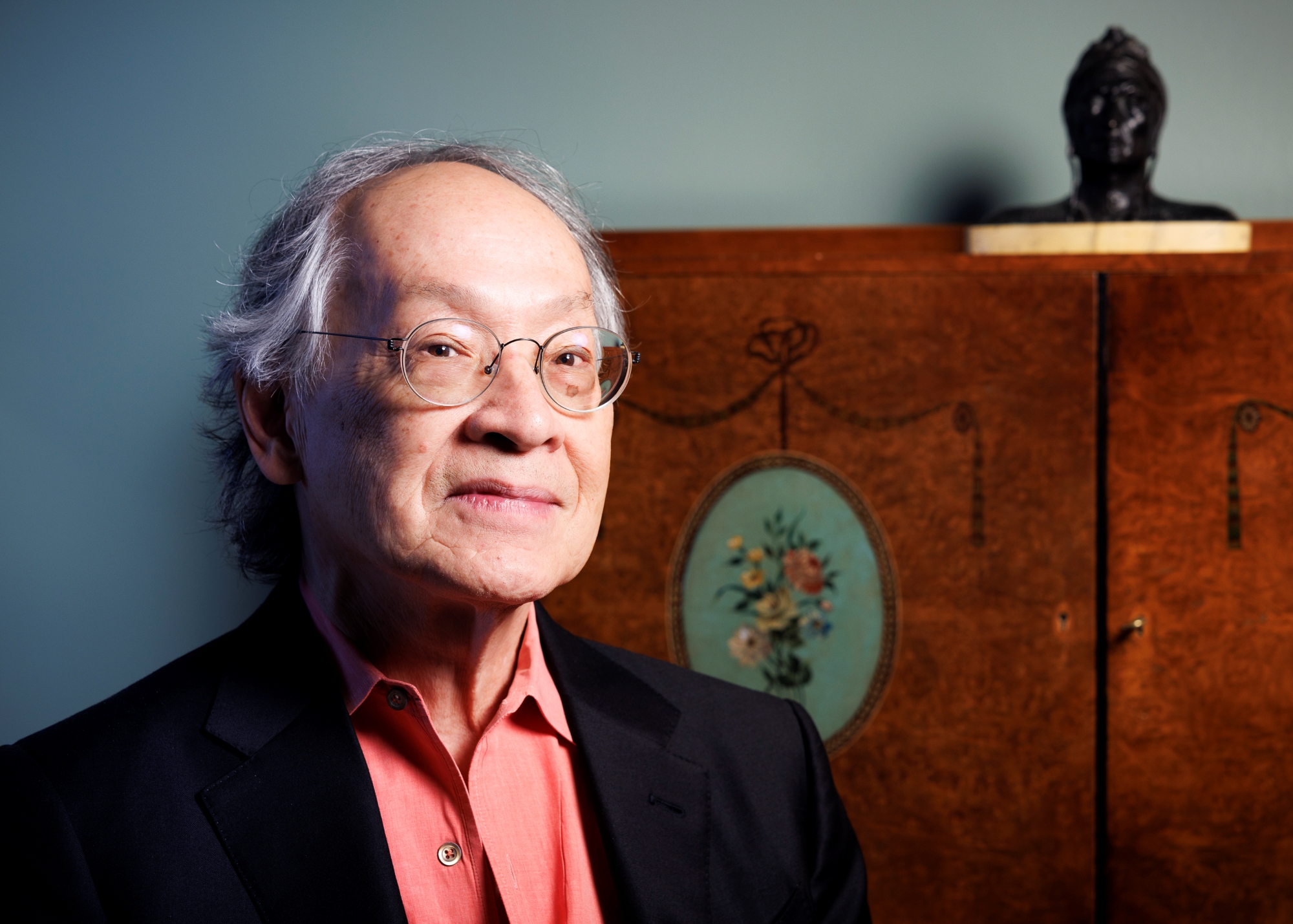 A closeup portrait of Arthur Sze '68. He is wearing a salmon-colored buttoned shirt beneath a black blazer.