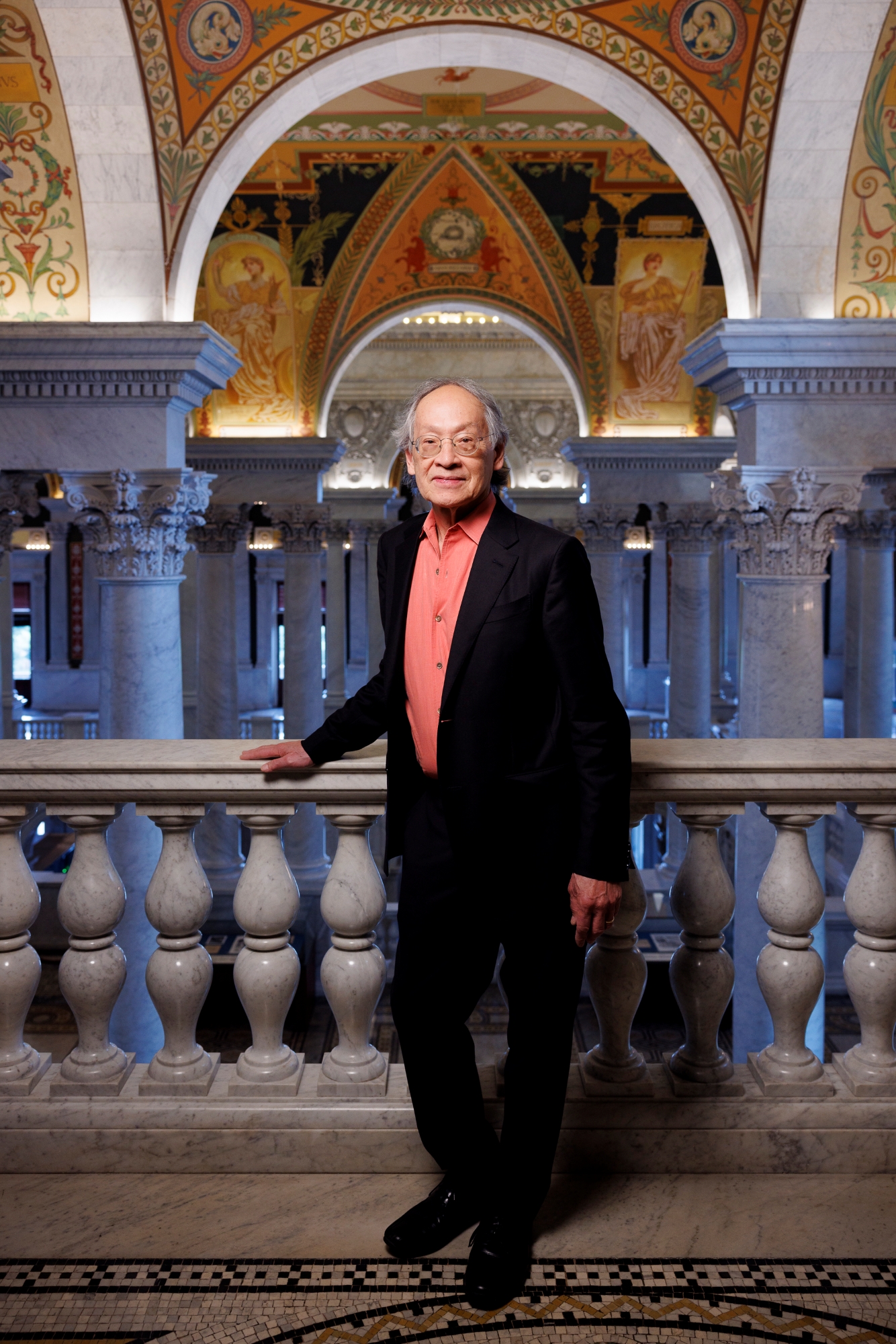 Arthur Sze '68 rests his hand on a marble railing inside the Library of Congress.