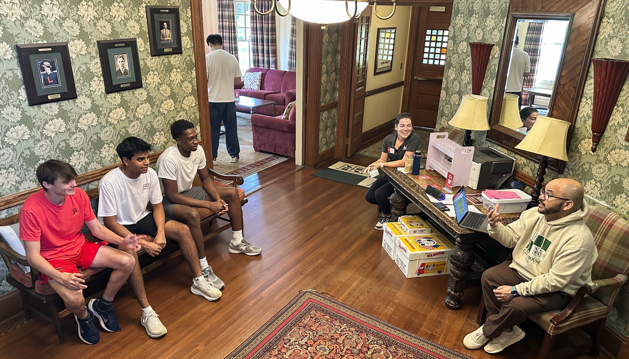 E.J. Hernandez, head of Cleve House, sits in the lobby of Cleve discussing things with three resident boys.