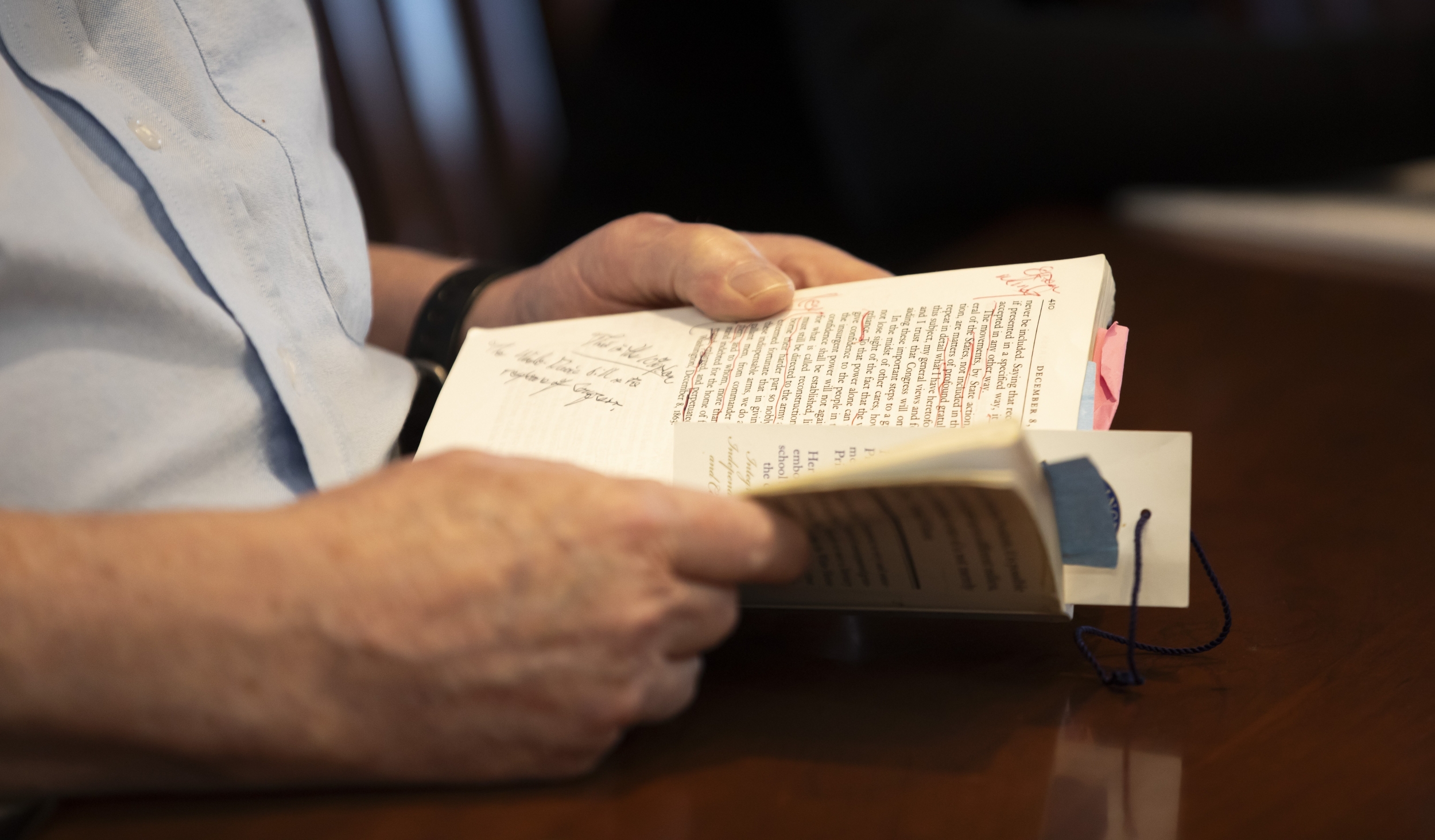 Closeup of the hands of Regan Kerney holding his Lincoln text showing his notes in the margins.