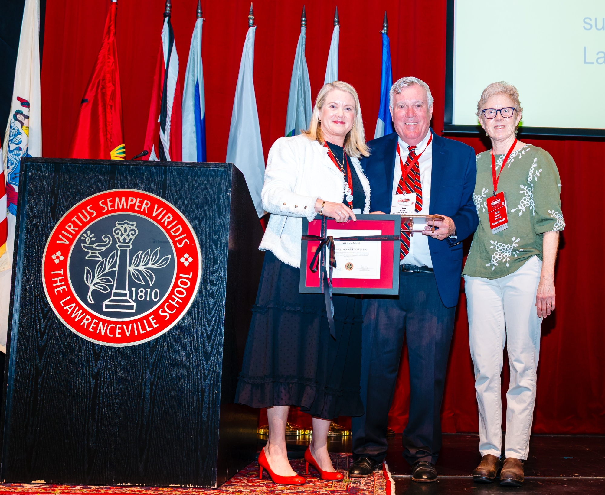 Alumni Association president Heather Elliott Hoover presents a framed Harkness Award certificate to Tim Doyle. He was presented by Kris Schulte.