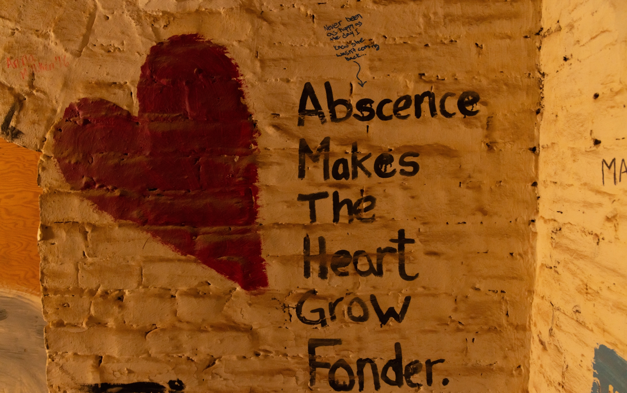 Against the white brick walls of the Memorial Hall basement, a red heart is painted next to the words "Abscence (sic) Makes the Heart Grow Fonder."