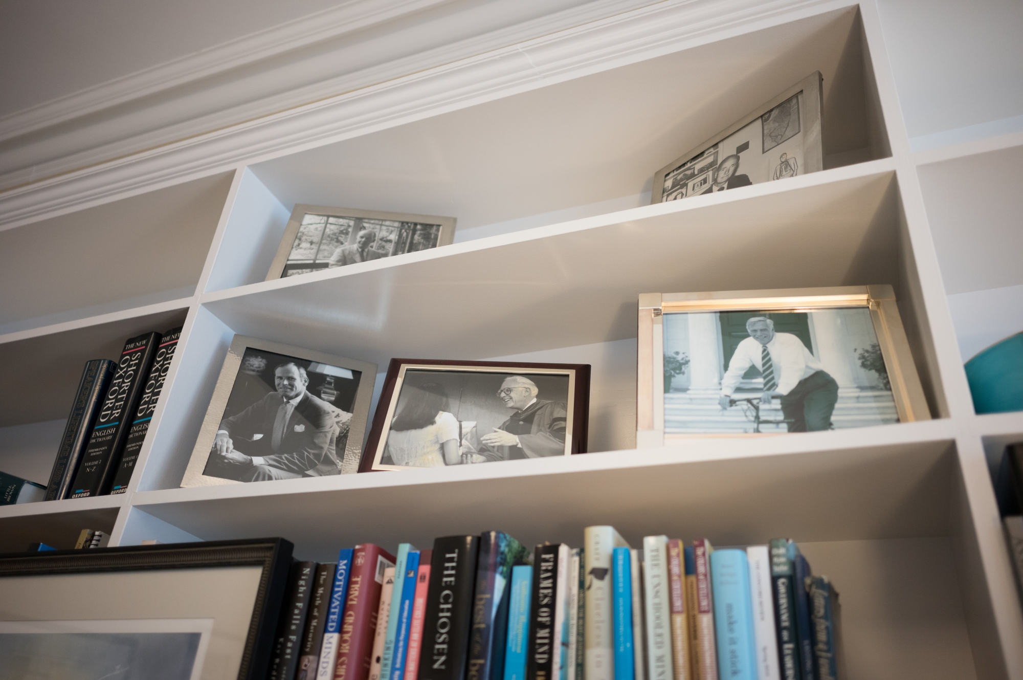 Small framed photos of several past heads of school sit on a bookcase shelf in Murray's office.