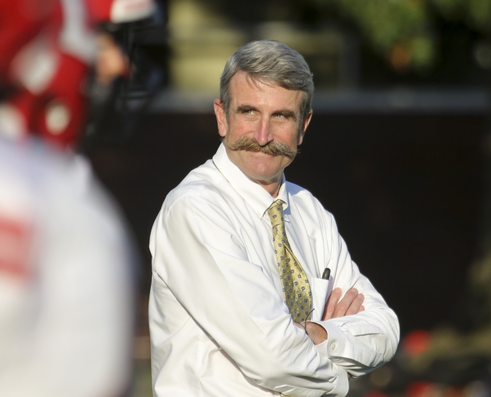 Steve Murray, wearing a white shirt and a light colored tie, has his arms folded as he looks off to action on his right side.